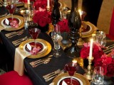 a Gothic wedding tablescape done in black, red and gold, with candles, red glasses and lush florals