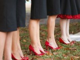 bridesmaids wearing black gowns, red shoes and carrying red rose bouquets
