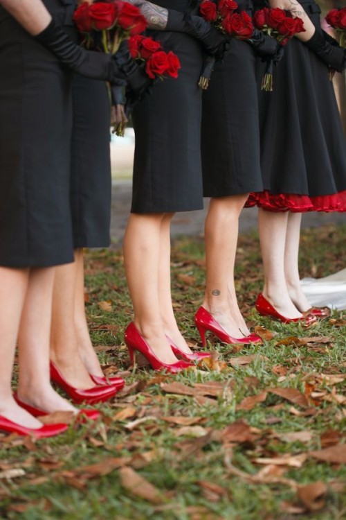 bridesmaids wearing black gowns, red shoes and carrying red rose bouquets