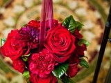 hot red bloom balls hanging on black metal holders for decorating the wedding aisle