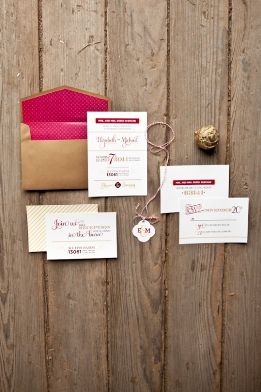 A stylish wedding invitation suite with a gold envelope and pink lining and invites done in pink, red and gold