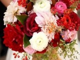 a bold wedding bouquet in deep red, pink, white, blush and with gold ribbons