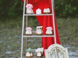 a ladder with gold vases and pink and red blooms plus some red fabric for glam and bold wedding decor