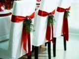 white chairs with red ribbon and evergreens are amazing for a winter wedding, accent your chairs and make them cooler