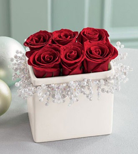 a winter wedding centerpiece of a white box with crystals and red roses inside is a chic and elegant idea for a winter wedding