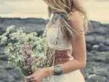 a boho chic bridal outfit with a lace crop top and a pencil skirt plus a wide sash, feather and chain earrings and a floral crown