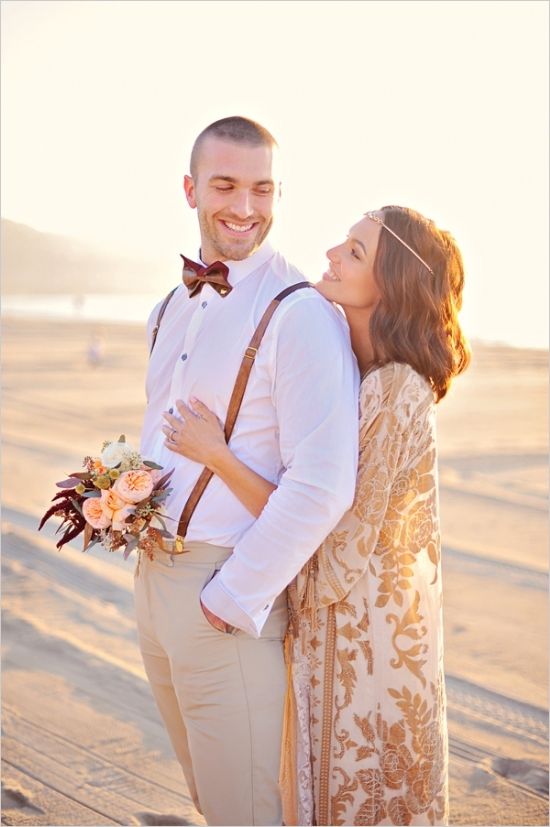 a simple boho beach groom's outfit with tan pants, a white shirt, suspenders and a printed bow tie