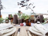 a simple boho beach reception table with wicker placemats, taupe candles, succulents and neutral porcelain