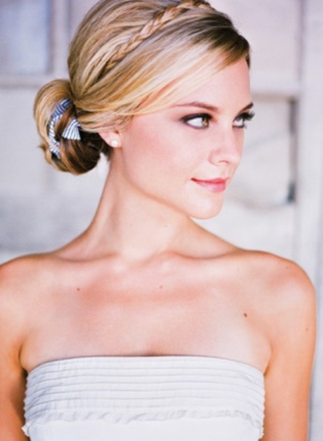 a low twisted bun with a blue ribbon and a delicate braided halo is a beautiful and refined idea