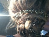 a messy twisted and braided low updo with a rhinestone ribbon for a touch of glam and chic is a lovely idea