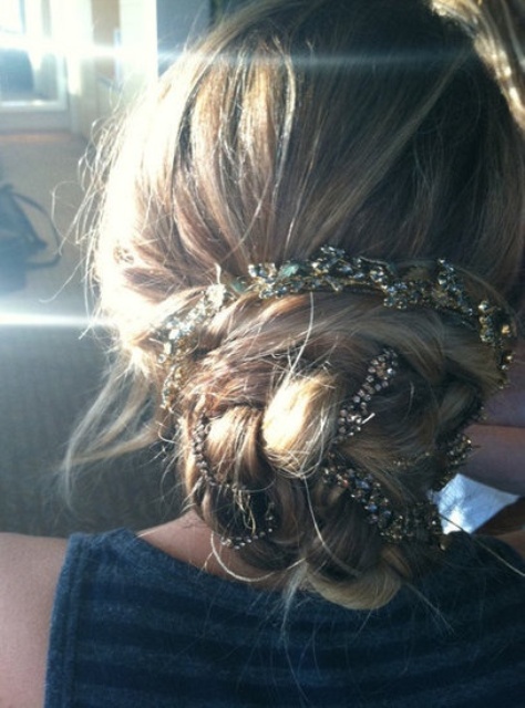 a messy twisted and braided low updo with a rhinestone ribbon for a touch of glam and chic is a lovely idea