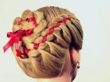 a complicated braided updo with a braided bun on top and a red ribbon is a creative idea for an elegant and vintage-inspired bride and will do for a Christmas wedding