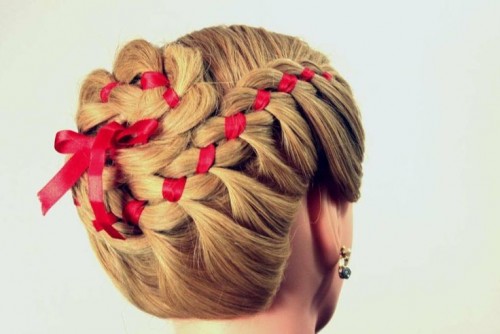 a complicated braided updo with a braided bun on top and a red ribbon is a creative idea for an elegant and vintage-inspired bride and will do for a Christmas wedding