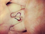 a mini red heart tattoo on the back of the ring finger that is divided into two parts is a very delicate thing