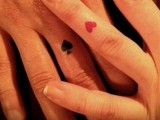 a black spade tattoo and a red heart one on the ring finger are fun and creative tattoos for card-loving couples
