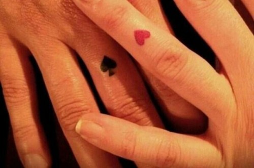 a black spade tattoo and a red heart one on the ring finger are fun and creative tattoos for card-loving couples