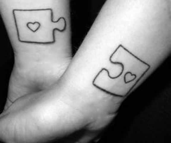 Large black and white puzzle tattoos with hearts on the wrists are creative and cool options to rock