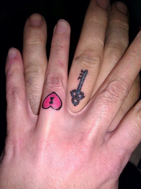 a heart-shaped and key-shaped tattoo as couple tattoos on the ring figers are a fun and bold idea instead of usual rings