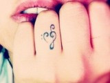 a treble clef heart-shaped tattoo on the ring figer is a lovely idea for those who love music