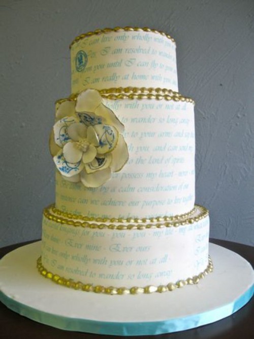 a white wedding cake with blue love letters on the tiers, with gold beads and a neutral sugar bloom is a beautiful solution with a romantic touch