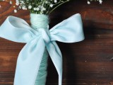 a baby’s breath wedding bouquet with a pale blue wrap and a bow is a lovely idea for an elegant and chic bride