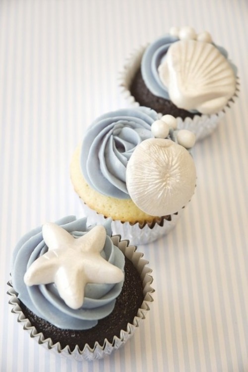 vanilla and chocolate cupcakes topped with pale blue frosting and pearls, shells and starfish are amazing for a seaside wedding