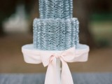 a pale blue wedding cake with frosting and a blush ribbon is a lovely idea for an ocean or seaside wedding