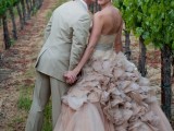 a dusty pink strapless wedding ballgown with a ruffled skirt and a silver sash for a chic vineyard wedding