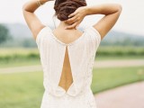 a stylish embellished sheath wedding dress with no sleeves, a cutout back and elegant beading here and there