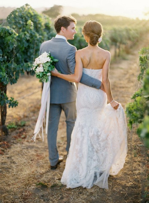 a white lace strapless mermaid wedding dress with a train is a stylish and very girlish idea for a vineyard bride