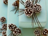 a light blue square wedding cake with snowy pinecones is a chic and bold dessert idea for your winter wedding