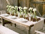 a natural wedding tablescape with burlap, pinecones, white blooms in tall glasses is neutral and chic