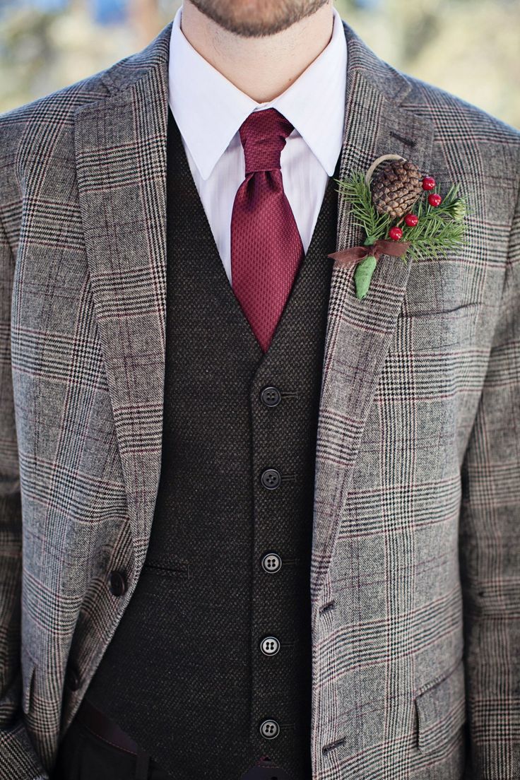 A stylish winter wedding boutonniere with a pinecone, berries and greenery is awesome to accent a groom's look