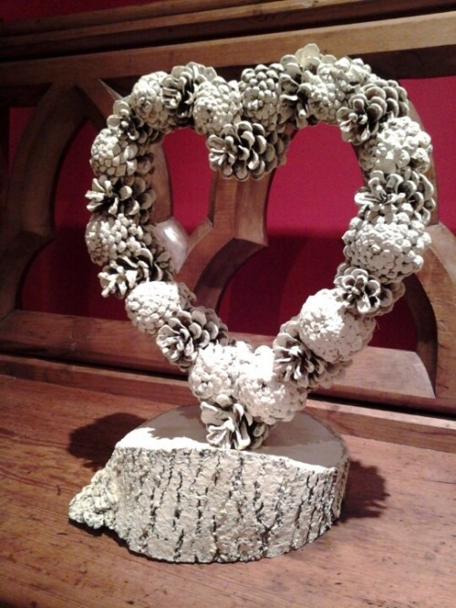 a snowy pinecone wreath on a wooden stand is a stylish decoration for a winter wedding