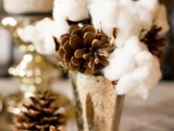 a refined winter wedding decoration of a mercury glass vase, cotton and pinecones is a lovely and chic idea