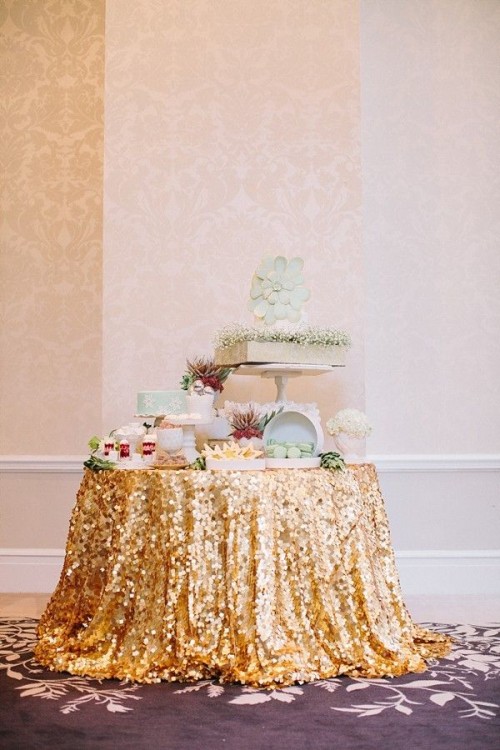 a bold wedding dessert table covered with a gold sequin tablecloth, with lots of desserts and succulents is an awesome idea