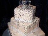 a tan square wedding cake with silver beads and champagne glasses on top is a chic and shiny idea