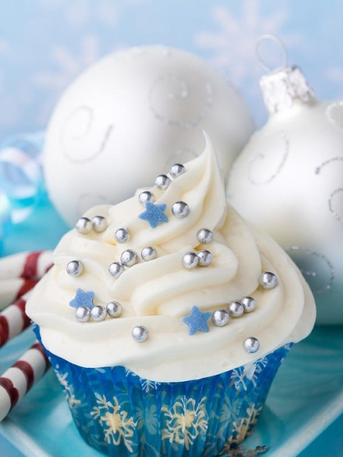 a white swirl cupcake topped wiht silver beads and blue stars is a cool wedding dessert for a glam or other NYE wedding