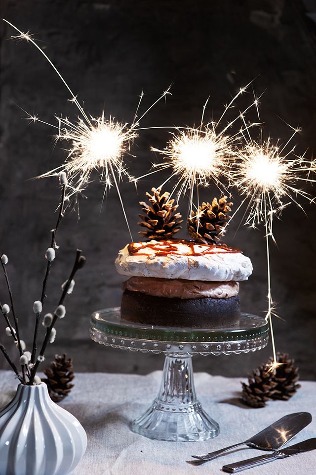 A small naked wedding cake with pinecones, caramel drip on top and some sparklers is a lovely idea for a NYE wedding