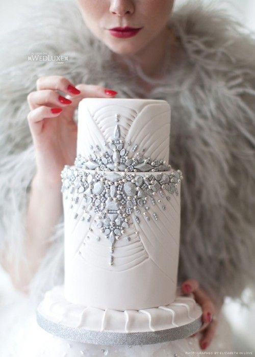 a white textural wedding cake heavily embellished with grey edible gems and beads is very refined and chic