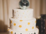 a NYE wedding cake with a city look, some stars, beads and a disco ball on top is lovely