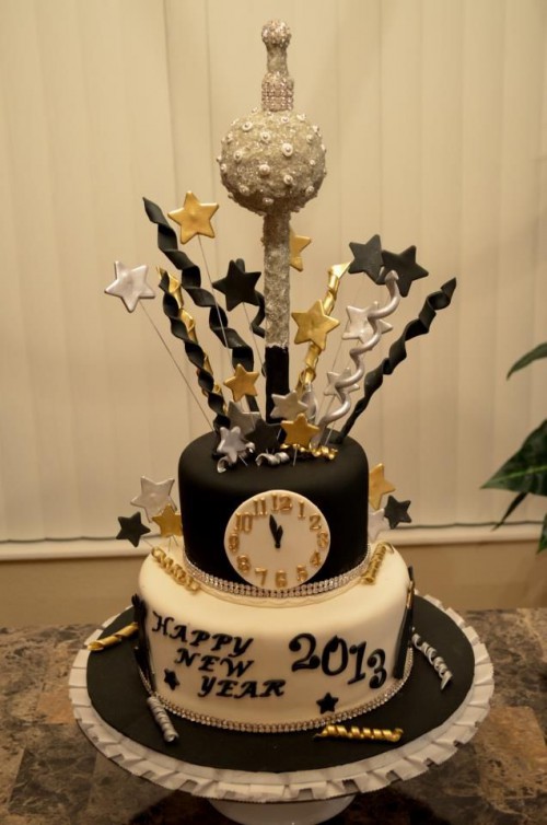 a black and white wedding cake with a clock, stars, letters and a crazy star cake topper to inspire partying all night long