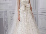 a fully embellished A-line wedding dress with an illusion neckline, cap sleeves and a large bow is a chic idea to rock