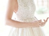 an A-line wedding dress with a white sequin sleeveless bodice with a high neckline and a shiny full skirt is a non-typical solution to rock