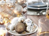 a winter wedding tablescape with a glass jar with silver and other metlalic ornaments, a bowl with them – these arrangements act as winter wedding centerpieces