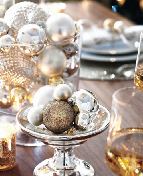 a winter wedding tablescape with a glass jar with silver and other metlalic ornaments, a bowl with them - these arrangements act as winter wedding centerpieces