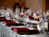 a grey and burgundy Halloween tablescape with elegant glasses, cutlery, and candles is chic and moody