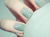 pastel green nails with mismatching white polka dots at the bottom of the nail are amazing for spring or fall
