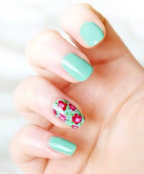 pastel green nails with a single accent one with pink and fuchsia blooms painted on it is a veyr bright and cool idea to rock