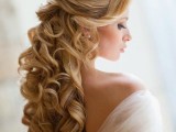 a sophisticated and refined wedding half updo with a volume on top and waves and curls down, with a chic rhinestone hairpiece is a chic idea for a refined bride